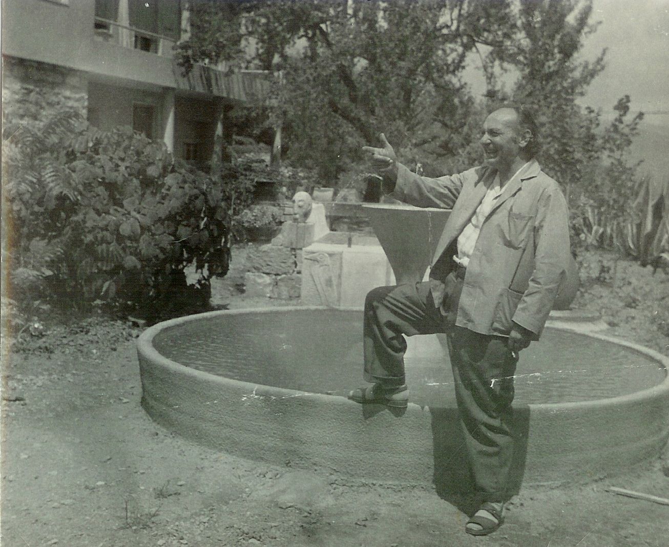Gino Maggioni accanto a una fontana in giardino